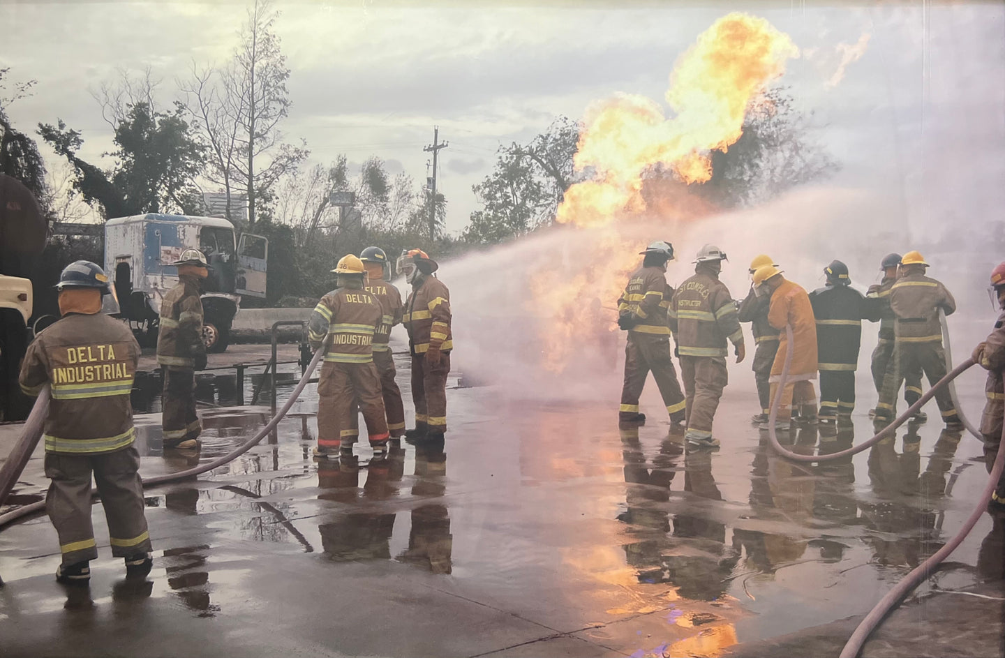 Firefighters wearing Delta Industrial turnout coats at an outdoor industrial fire training exercise.