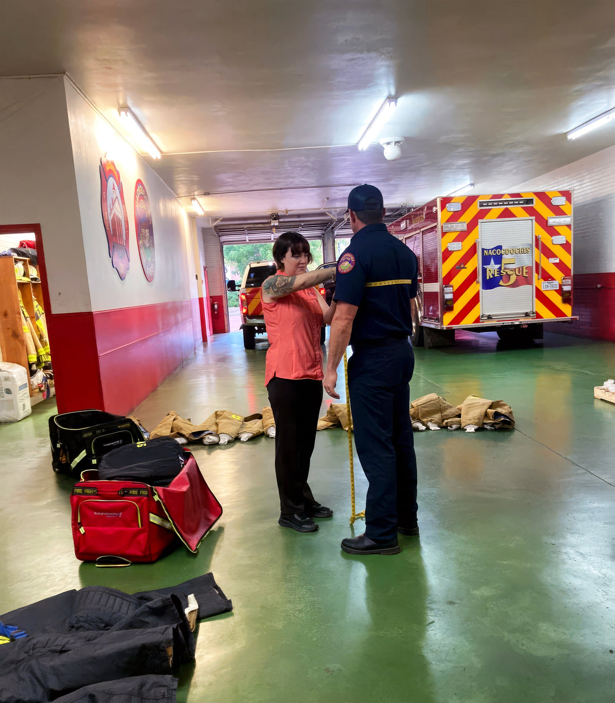 Delta team member taking a firefighter's measurements beside fire apparatus