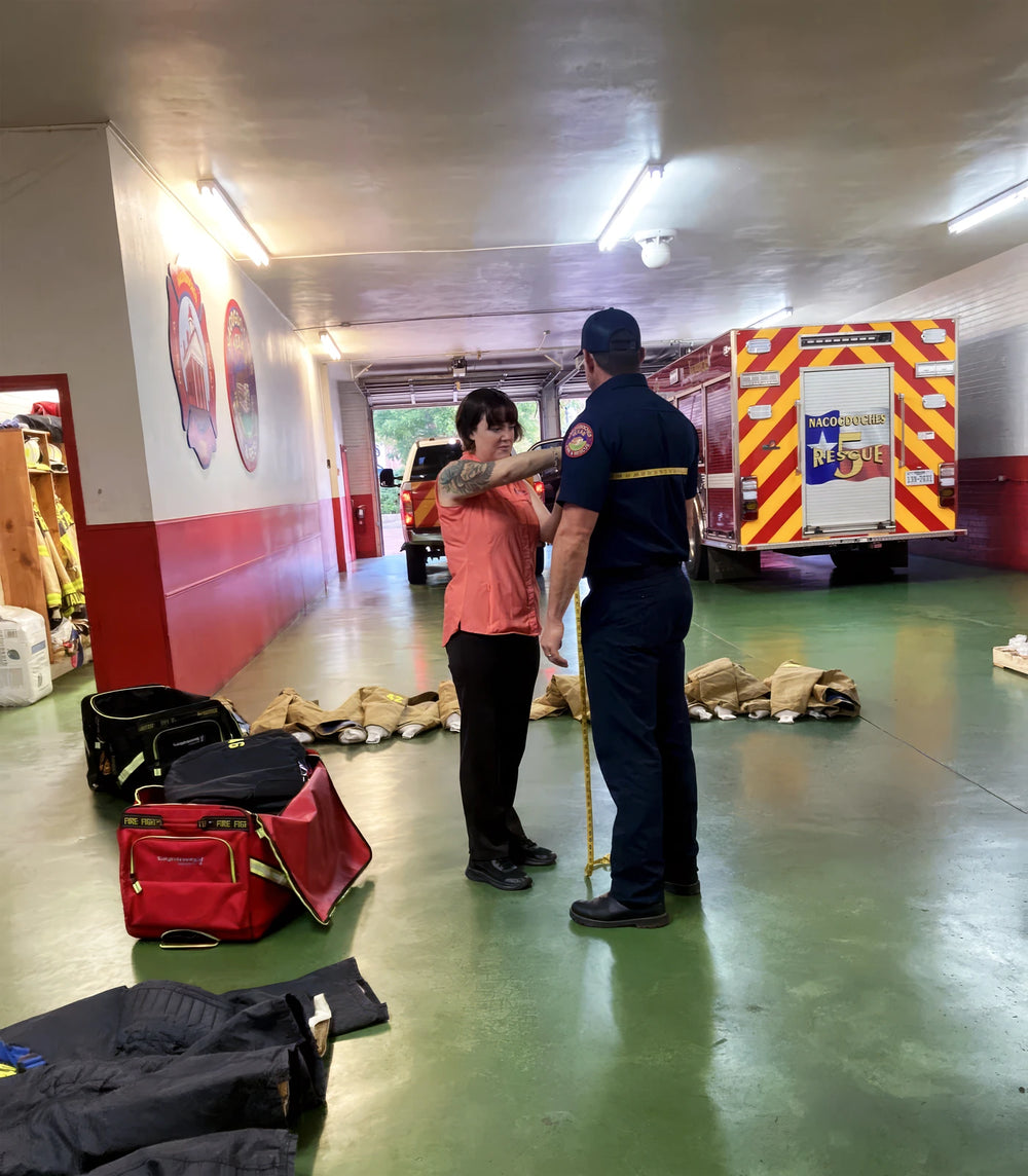 Delta team member taking a firefighter's measurements beside fire apparatus